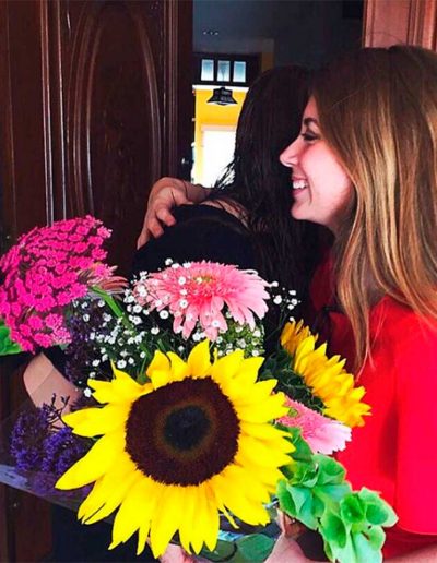 mujer contenta recibiendo hermoso arreglo con girasoles de Floreria Plaza Tampico